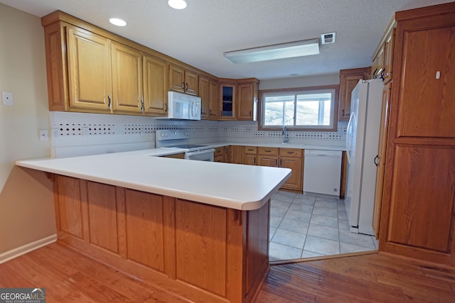 3112 Allison Ct, Young Harris, GA 30582 - kitchen featuring light wood-type flooring, white appliances, decorative backsplash, visible vents, and a peninsula