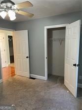 370 Rainey Dr, Dawsonville, GA 30534 - unfurnished bedroom featuring baseboards, a closet, ceiling fan, and carpet flooring