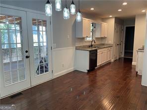 370 Rainey Dr, Dawsonville, GA 30534 - kitchen with french doors, a sink, dark wood finished floors, black dishwasher, and decorative light fixtures