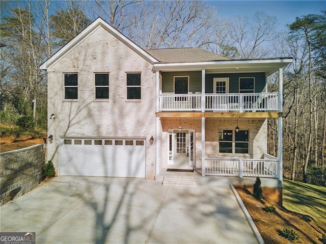 5726 Ridgewater Cir, Gainesville, GA 30506 - view of front facade with covered porch, concrete driveway, brick siding, a balcony, and a garage