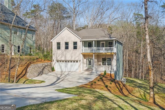 5726 Ridgewater Cir, Gainesville, GA 30506 - view of front facade featuring concrete driveway, stucco siding, an attached garage, a balcony, and a porch