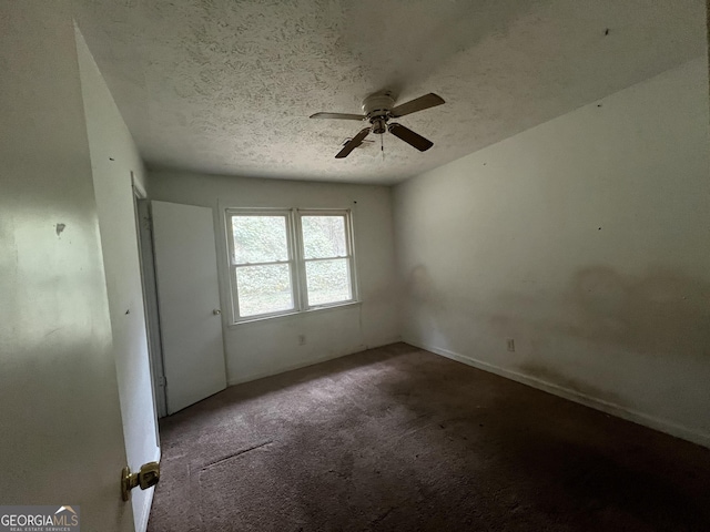 carpeted spare room with ceiling fan and a textured ceiling