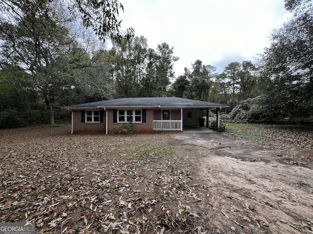 view of front of house featuring an attached carport, driveway, and brick siding