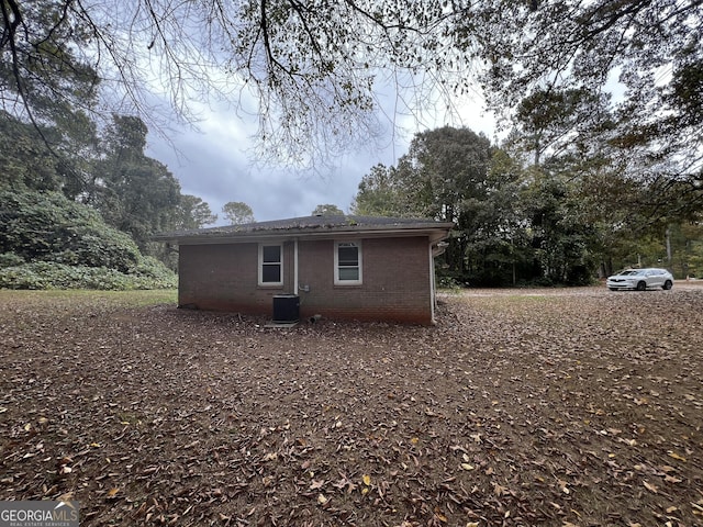 rear view of house with brick siding and cooling unit