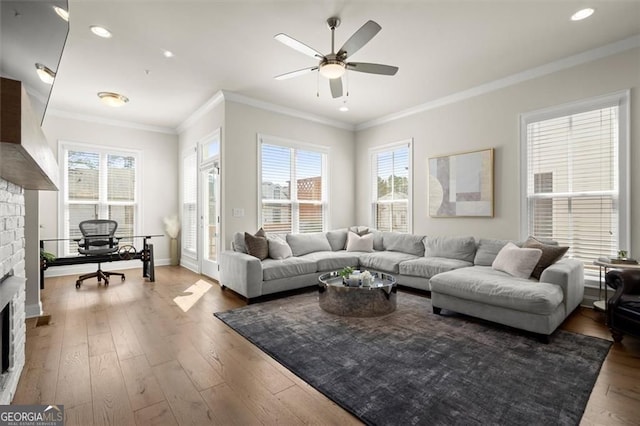 living room with a ceiling fan, a fireplace, hardwood / wood-style floors, ornamental molding, and recessed lighting