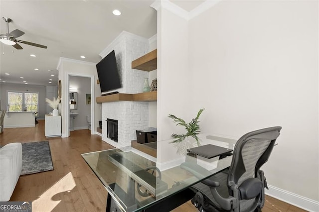 home office featuring a brick fireplace, crown molding, baseboards, ceiling fan, and recessed lighting
