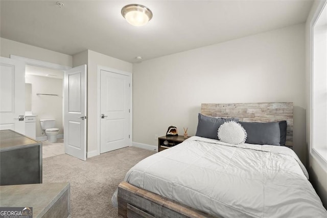 bedroom featuring connected bathroom, carpet floors, and baseboards
