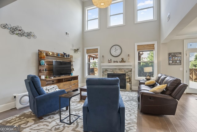 11395 Crestview Ter, Johns Creek, GA 30024 - living room with plenty of natural light, a stone fireplace, a high ceiling, baseboards, and wood finished floors