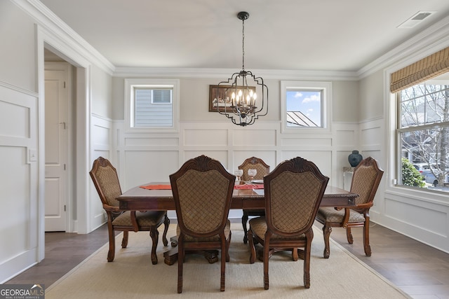 11395 Crestview Ter, Johns Creek, GA 30024 - dining area with a chandelier, a decorative wall, wainscoting, and ornamental molding