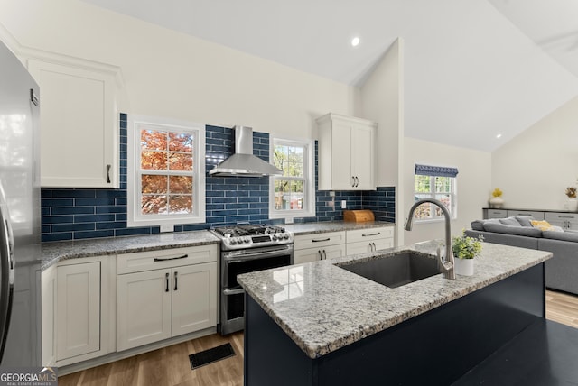 385 Jayne Ellen Way, Alpharetta, GA 30009 - kitchen featuring stainless steel appliances, wall chimney range hood, a sink, vaulted ceiling, and light wood-style flooring