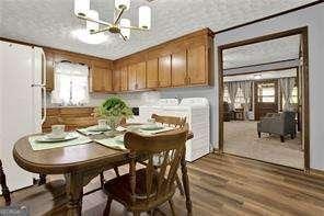 dining space with plenty of natural light, dark wood-type flooring, and an inviting chandelier