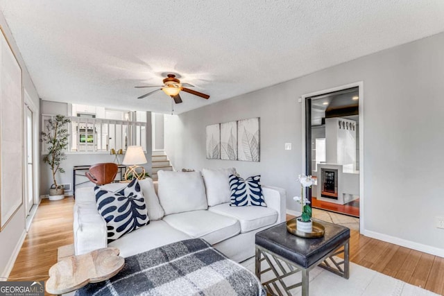 4519 Glenforest Dr NE, Roswell, GA 30075 - living area featuring stairs, baseboards, a textured ceiling, light wood-style floors, and ceiling fan
