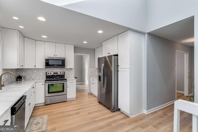 4519 Glenforest Dr NE, Roswell, GA 30075 - kitchen with a sink, white cabinets, light wood-style floors, and appliances with stainless steel finishes