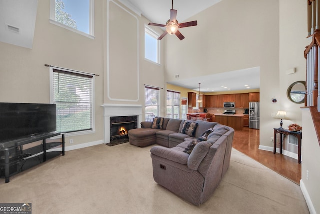 1210 Spring Branch Ct, Lawrenceville, GA 30045 - living area featuring a towering ceiling, healthy amount of natural light, a ceiling fan, and a premium fireplace