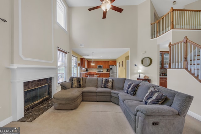 1210 Spring Branch Ct, Lawrenceville, GA 30045 - living room featuring a towering ceiling, a ceiling fan, healthy amount of natural light, a high end fireplace, and stairway
