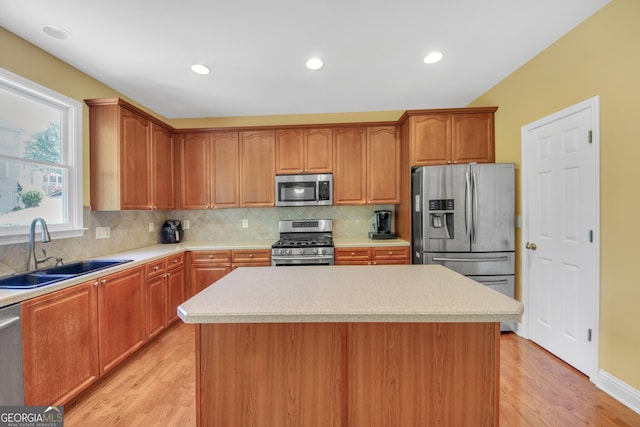 1210 Spring Branch Ct, Lawrenceville, GA 30045 - kitchen featuring appliances with stainless steel finishes, light wood finished floors, a kitchen island, light countertops, and decorative backsplash