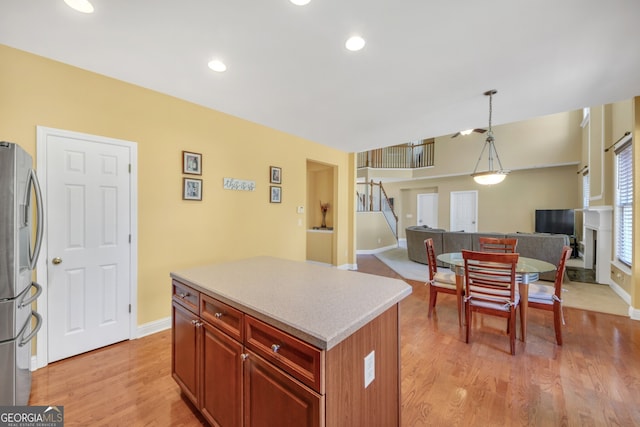 1210 Spring Branch Ct, Lawrenceville, GA 30045 - kitchen with freestanding refrigerator, open floor plan, a center island, light wood-style flooring, and light countertops