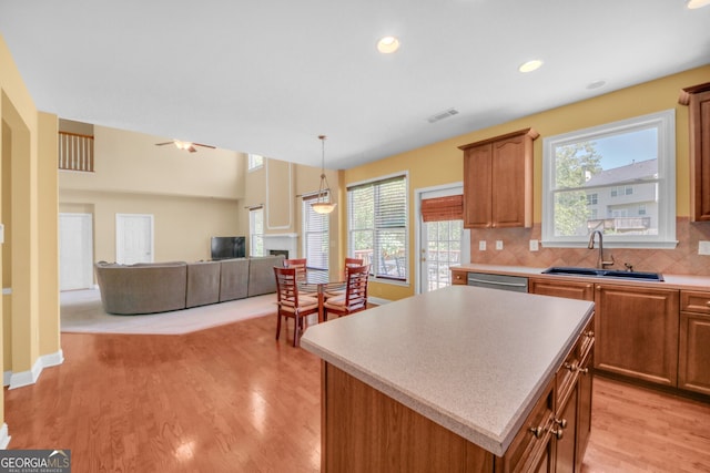 1210 Spring Branch Ct, Lawrenceville, GA 30045 - kitchen with a kitchen island, dishwasher, light countertops, decorative backsplash, and light wood-style floors