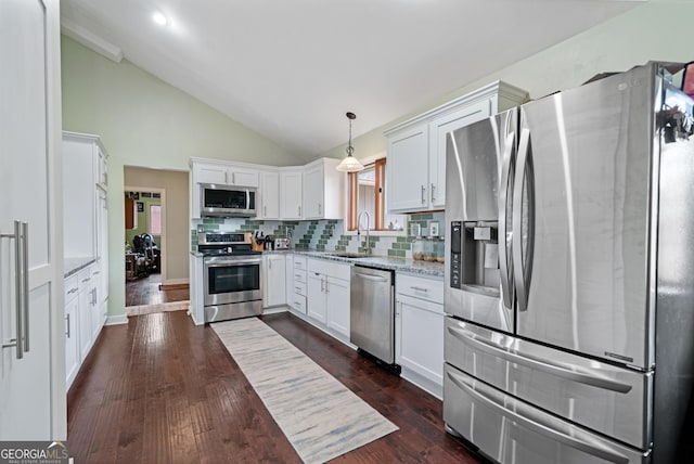 kitchen with stainless steel appliances, dark wood finished floors, a sink, light stone counters, and white cabinets