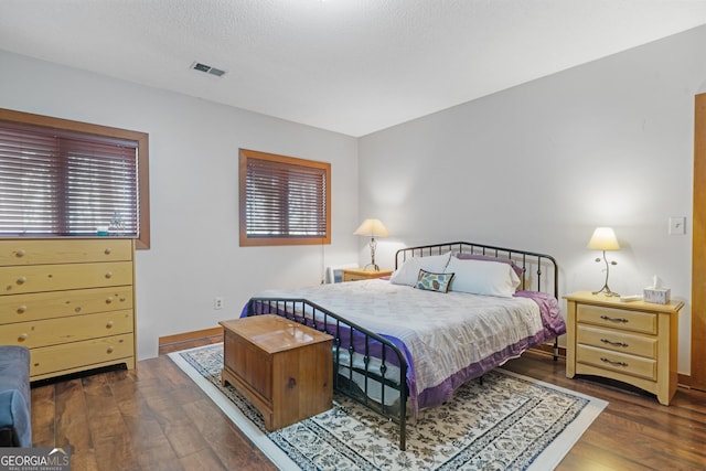 bedroom featuring visible vents and wood finished floors