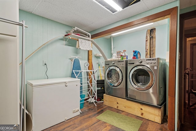 clothes washing area with washing machine and clothes dryer, laundry area, and wood-type flooring