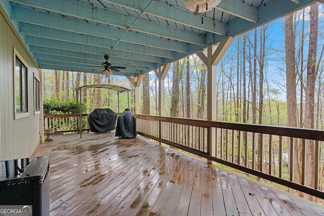 wooden terrace with grilling area and ceiling fan