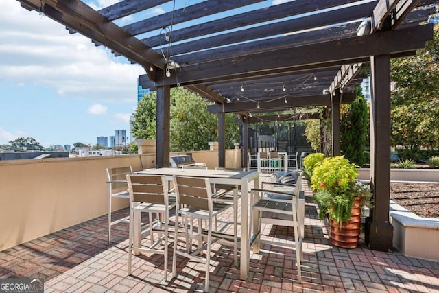 view of patio / terrace featuring outdoor dining area, a pergola, and a view of city