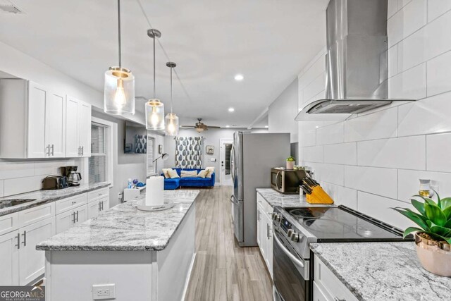 1115 Martin Luther King Jr Dr SW, Atlanta, GA 30314 - kitchen featuring a kitchen island, white cabinetry, wall chimney exhaust hood, stainless steel appliances, and ceiling fan