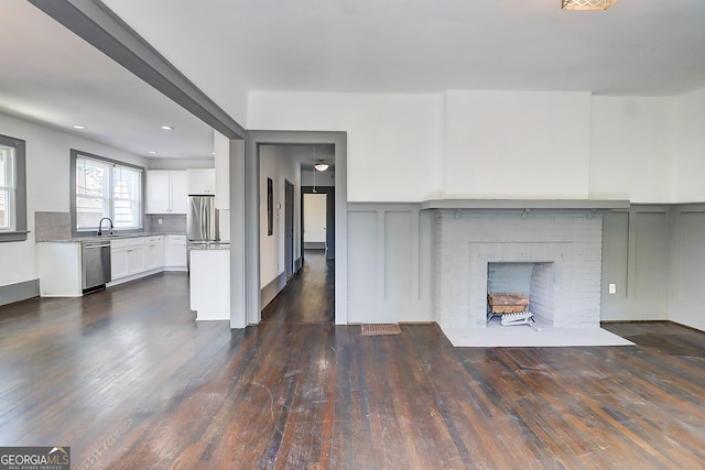 1497 Rogers Ave SW, Atlanta, GA 30310 - unfurnished living room with dark wood finished floors, a fireplace, a sink, a decorative wall, and recessed lighting