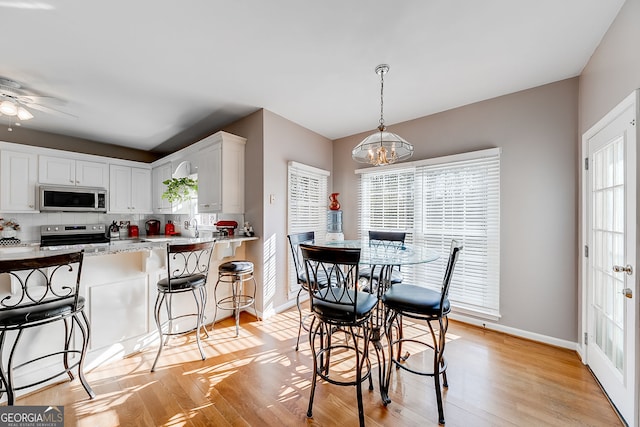5045 Southern Trace Dr, Gainesville, GA 30504 - dining room with baseboards, a chandelier, light wood finished floors, and ceiling fan