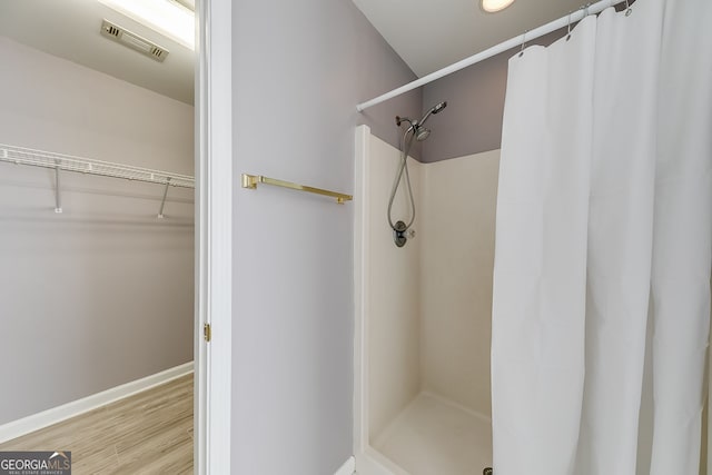 5045 Southern Trace Dr, Gainesville, GA 30504 - bathroom with curtained shower, a walk in closet, wood finished floors, and baseboards