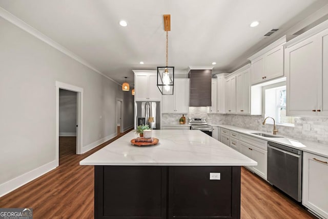 112 E Fambrough St, Monroe, GA 30655 - kitchen with appliances with stainless steel finishes, a sink, white cabinetry, a kitchen island, and recessed lighting