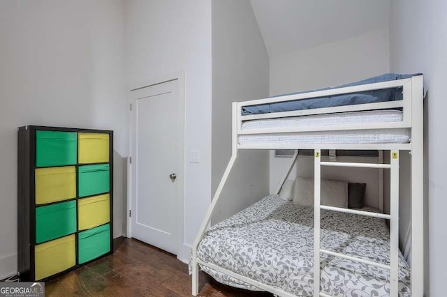 bedroom with wood finished floors and vaulted ceiling