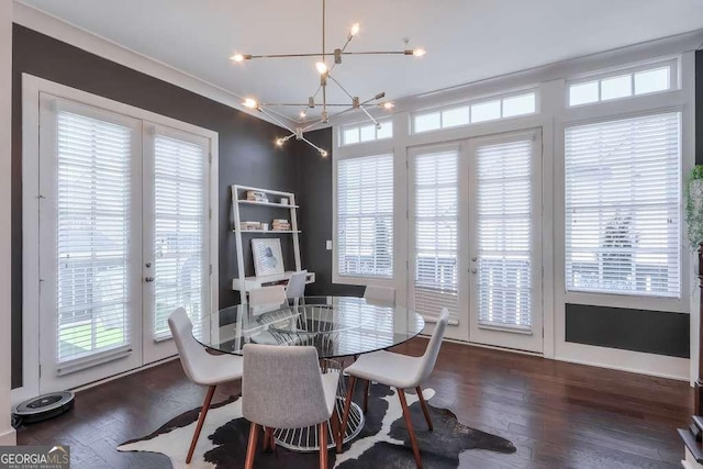 dining space with crown molding, wood finished floors, french doors, and a chandelier