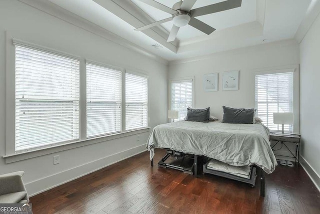 bedroom featuring baseboards, crown molding, hardwood / wood-style flooring, and a raised ceiling