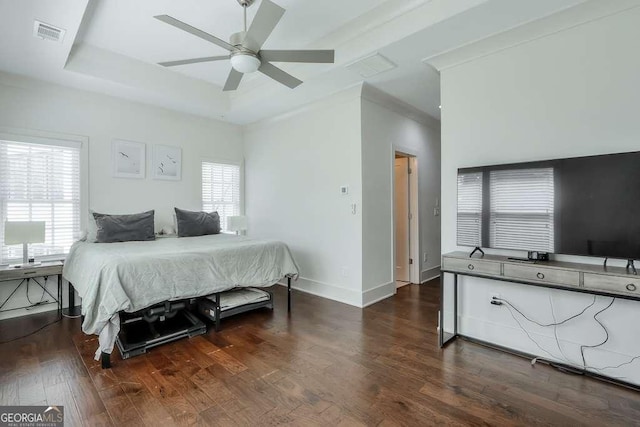 bedroom with a ceiling fan, a raised ceiling, baseboards, visible vents, and dark wood-type flooring