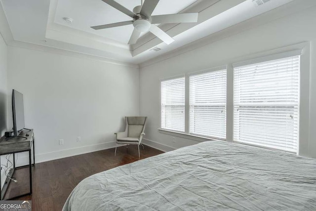 bedroom with baseboards, a ceiling fan, wood finished floors, and a raised ceiling