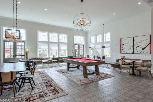 rec room with recessed lighting, a towering ceiling, ornamental molding, and a chandelier