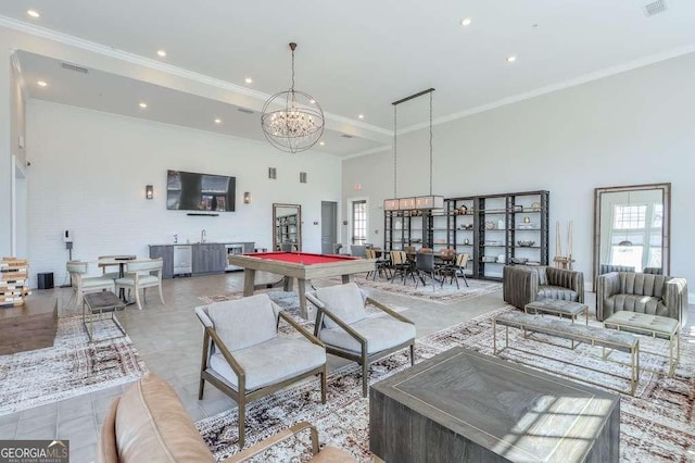 tiled living room with crown molding, a high ceiling, visible vents, recessed lighting, and an inviting chandelier