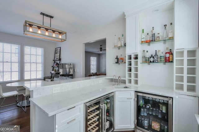 bar featuring a sink, indoor wet bar, dark wood-type flooring, and wine cooler
