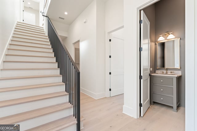 stairs featuring recessed lighting, baseboards, visible vents, and wood finished floors