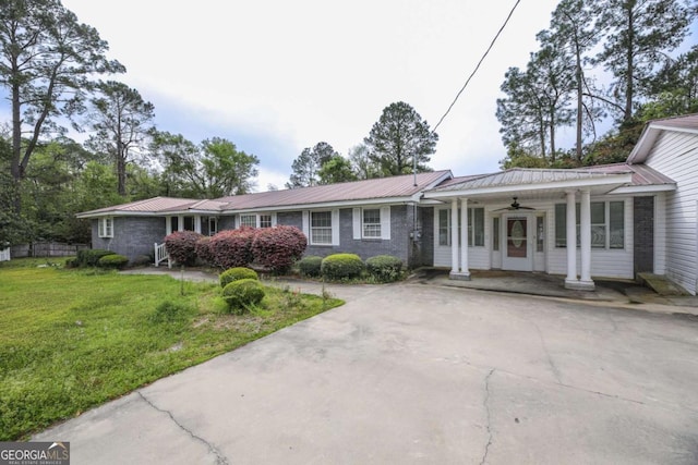 1100 Atlantic Ave, Waycross, GA 31501 - single story home featuring a ceiling fan, a front yard, a metal roof, and concrete driveway