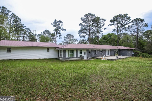 1100 Atlantic Ave, Waycross, GA 31501 - rear view of house with a patio, a lawn, and a metal roof