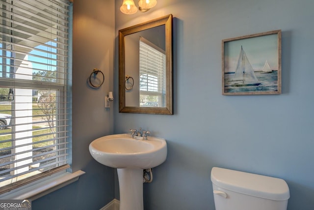 half bath featuring toilet and a wealth of natural light