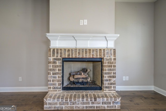 details with a brick fireplace, baseboards, and wood finished floors