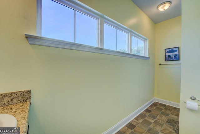 interior space with stone finish floor and baseboards