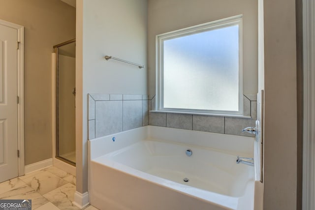 full bath featuring a bath, a stall shower, marble finish floor, and baseboards
