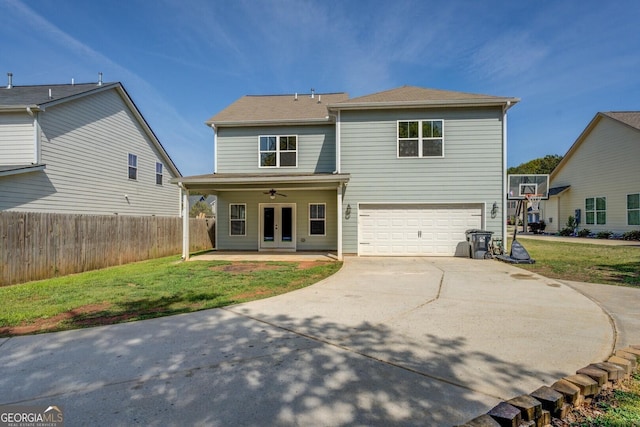 rear view of house with a yard, french doors, a garage, and concrete driveway