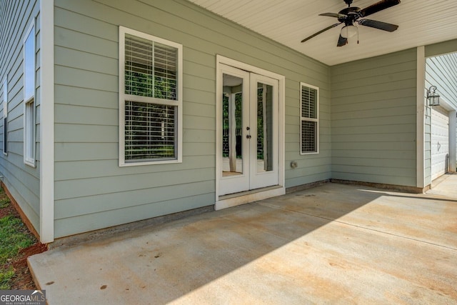 view of exterior entry with french doors, ceiling fan, and a patio