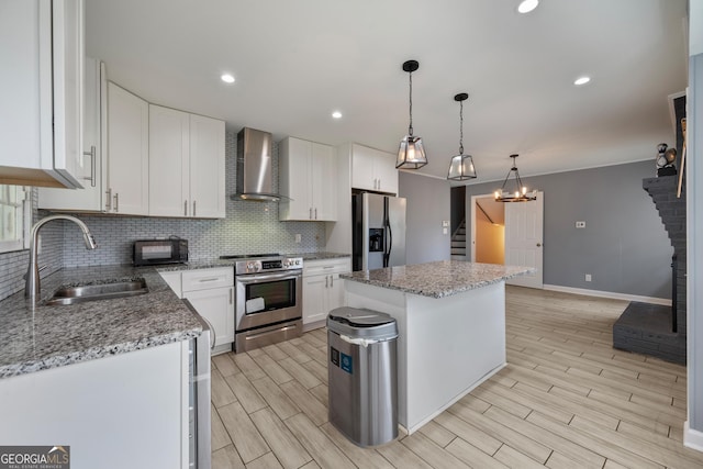 4329 Cedar Valley Ln, Conley, GA 30288 - kitchen featuring appliances with stainless steel finishes, wall chimney range hood, a kitchen island, tasteful backsplash, and white cabinets